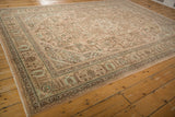 Distressed vintage Tabriz rug revealing even wear, geometric floral motifs in beige and mint.