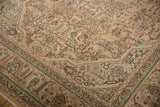 Distressed vintage Tabriz carpet, geometric floral pattern detail in dusty rose, beige, mint green.