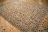 Geometric border patterns with faded rose and beige tones on a distressed vintage Tabriz rug.