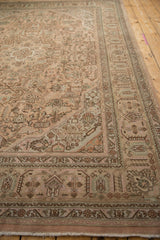 Distressed vintage Tabriz carpet's geometric floral designs in soft dusty rose and mint tones.