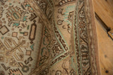 Curled edge of vintage distressed Tabriz, beige and brown geometric patterns, mint accents.