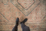 Detail of distressed pile texture, beige, rose, and jade Herati pattern on vintage Tabriz.