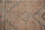 Distressed Persian Tabriz carpet features Herati pattern in beige, dusty rose, and jade green.