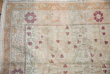 Distressed Sivas carpet corner showing delicate floral vinery, abrashed pile, and fringe.