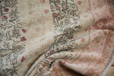 Distressed Sivas carpet fold showing abrash, faded ivory, dusty blush, and cochineal red florals.