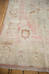 Worn pile and faded copper, pink, ivory patterns on a vintage Oushak runner.
