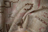 Distressed vintage Oushak rug with worn pile, faded pink, brown patterns, and visible foundation.