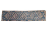 Vintage distressed Melas runner featuring blue geometric medallions, dusty rose accents, and a sand-colored ground.