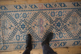 Even wear on the low pile of a distressed Melas runner, showing blue hook-and-latch motifs.