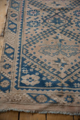 Even wear across the knot heads and stylized geometric border of a distressed Melas rug runner.