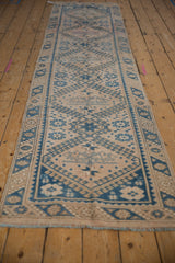 Angled perspective of a distressed Melas runner with a single column of geometric blue medallions.