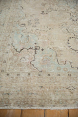 Distressed vintage Tabriz carpet with worn pile, faint foundation, and soft ivory and powder blue.