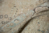 Soft, worn pile of the distressed vintage Tabriz carpet, showing subtle powder blue and neutral tones.