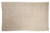 Vintage distressed Oushak carpet with an oversized, faded medallion in soft tones of ivory, beige, and sand.