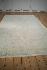Vintage Oushak carpet's lustrous pile and time-softened tones seen from a low angle.