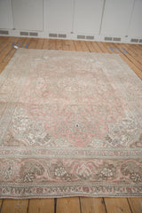 Intricate scrolling arabesques and floral cartouches on the distressed dusty rose Tabriz rug corner.