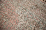 Distressed vintage Tabriz rug detail with worn dusty rose and pale coffee floral vinery.
