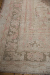 Muted pink, ivory, coffee brown Oushak rug border with distressed pile and surfaced knots.
