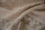 Distressed Oushak rug pile with nuanced density, showing pale coffee brown and blush tones.