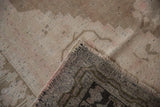 Distressed Oushak rug's textured pile in coffee, ivory, and blush, with visible woven foundation.
