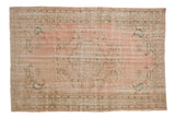 Vintage Distressed Oushak carpet with a soft pink field, central medallion, and green floral accents, 6x9.