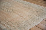 Distressed vintage Oushak carpet: worn pile with exposed foundation, faded apricot and olive tones.