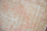 Worn pile of vintage distressed Oushak rug, foundation visible, in soft pink and neutral tones.