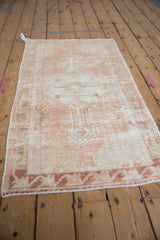 Distressed Oushak runner, close-up of worn pink pile and geometric coffee brown border.