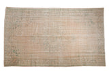 Distressed vintage Oushak carpet with faded peach field, worn mint medallion and spandrels, 6'10