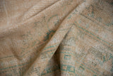 Textured pile of a distressed vintage Oushak rug, showing faded peach, ivory, and pale green patterns.