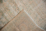 Distressed Oushak pile with faded rose and mint green, revealing foundation and selvage.