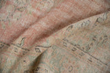 Soft, worn pile texture of a vintage distressed Oushak rug in rose and pale green.