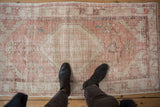 View showing the scale and worn texture of a vintage pink and ivory Oushak runner.