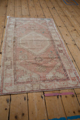Angled perspective of the distressed Oushak runner, showing its full design in faded pink and sand.