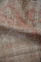 Close-up of the low pile and visible knot heads on a distressed vintage Oushak rug.