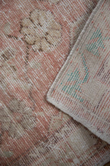 Close-up on the back of a distressed Oushak rug, revealing the colorful hand-knotted weave.
