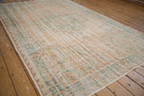 Hand-knotted distressed Oushak rug, worn dusty blush and faded teal floral patterns.