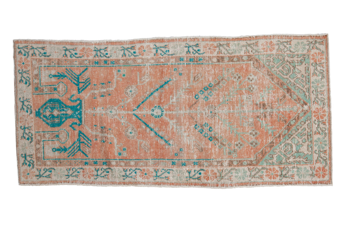 Vintage distressed Oushak runner with a prayer design in pale melon, turquoise, and sea foam green.
