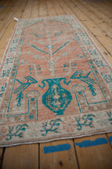 Angled perspective of a distressed Oushak runner showing its turquoise vase motif.