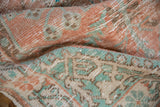 Even wear across the knot heads of a Turkish Oushak rug in pale melon and sea foam green.
