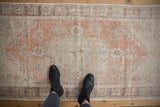 Distressed Oushak runner texture with muted blush, beige, and seafoam green tones.