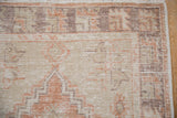 Distressed Oushak rug corner showing stepped spandrel, textural wear, blush and beige.