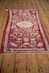 Distressed Oushak rug runner corner showing wear to pile and original side selvages.