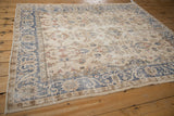 Angled close-up of distressed Turkish Sparta rug with faded cobalt arabesque border, ivory field.