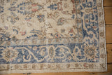 Distressed Sparta rug corner, featuring faded ivory, blue arabesque vine patterns and visible wear.