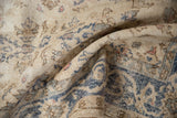 Faded slate blue and ivory floral patterns with knot-head wear on a distressed Sparta rug.
