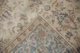 Folded corner of distressed Sparta rug showing faded cobalt field and slate blue main border.