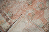 Distressed vintage Oushak rug's worn pile, exposed foundation, and hand-knotted reverse.