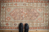 Vintage distressed Oushak rug showing faded floral designs, visible foundation, and starburst border.