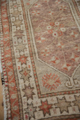 Faded brick red geometric starburst border on a distressed vintage Oushak rug.